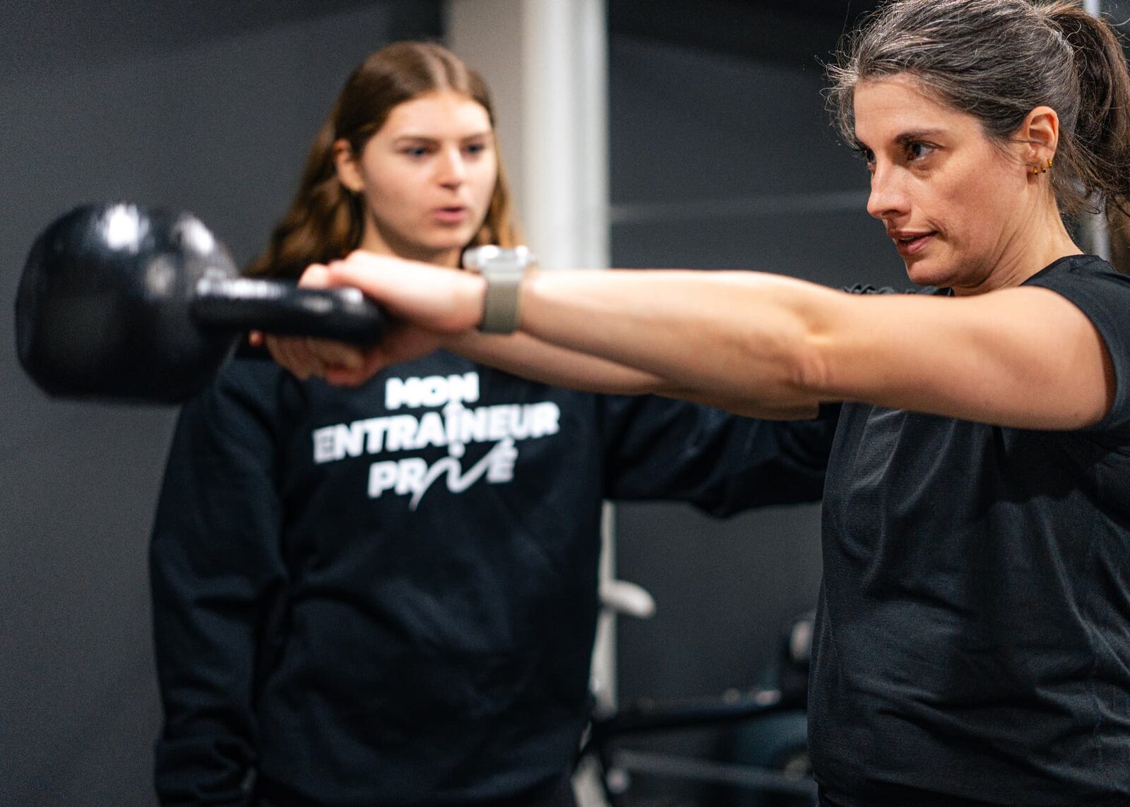Kinésiologue corrigeant un exercice au kettlebell